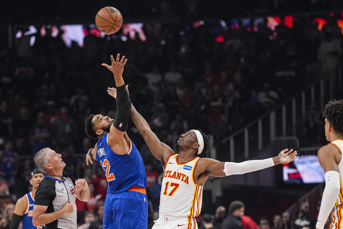 Apr 25, 2026; Atlanta, Georgia, USA; New York Knicks center Karl-Anthony Towns (32) and Atlanta Hawks forward Onyeka Okongwu (17) reach for the ball during the opening tip off during the first half at State Farm Arena. Mandatory Credit: Dale Zanine-Imagn Images